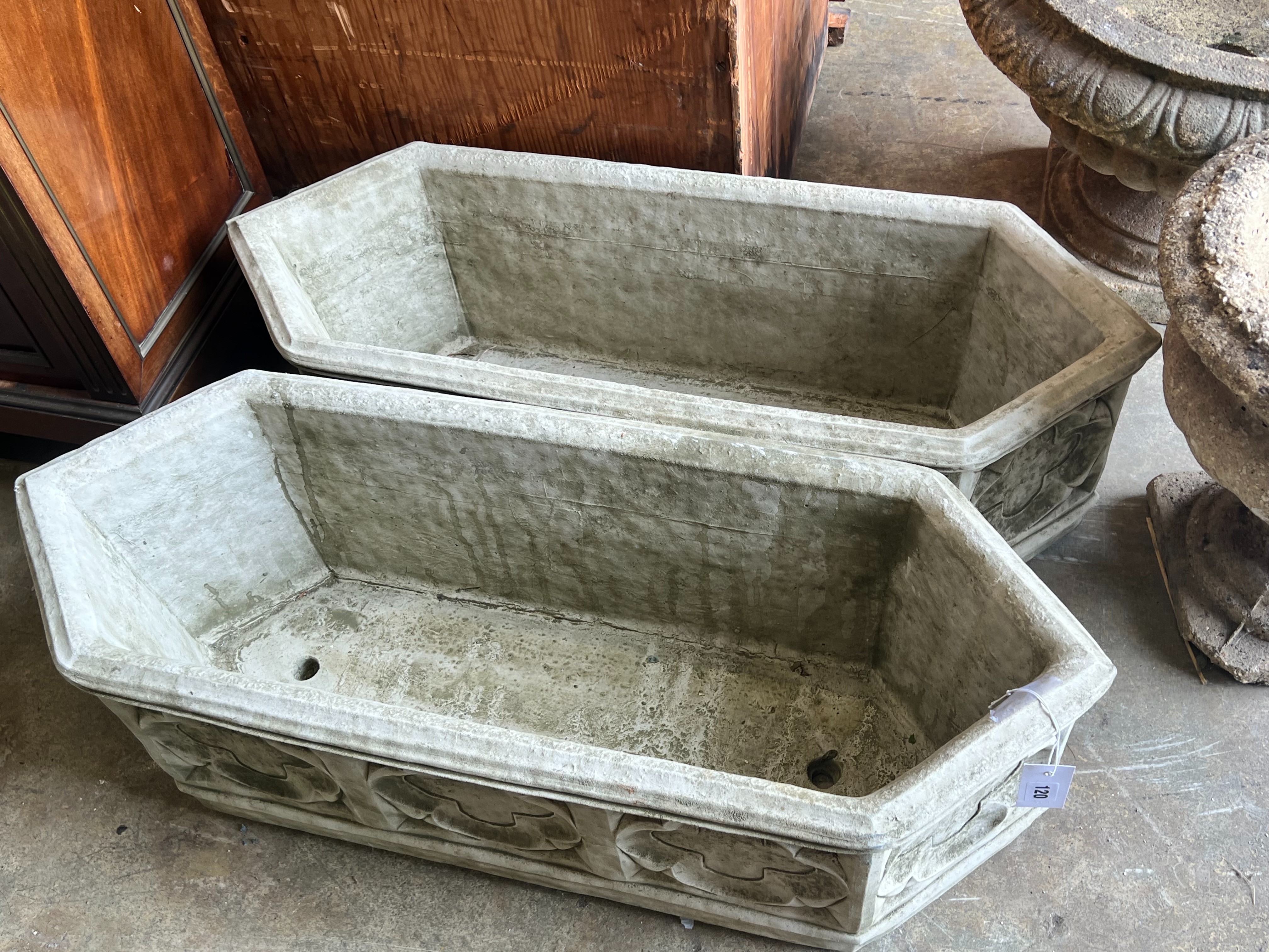 A pair of Gothic style reconstituted stone garden planters of elongated hexagonal form, width 88cm depth 33cm height 28cm